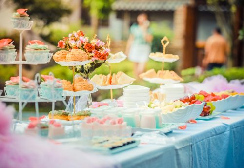 A vibrant outdoor buffet table showcasing an array of colorful pastries and fruits, perfect for parties.