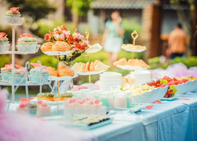 A vibrant outdoor buffet table showcasing an array of colorful pastries and fruits, perfect for parties.