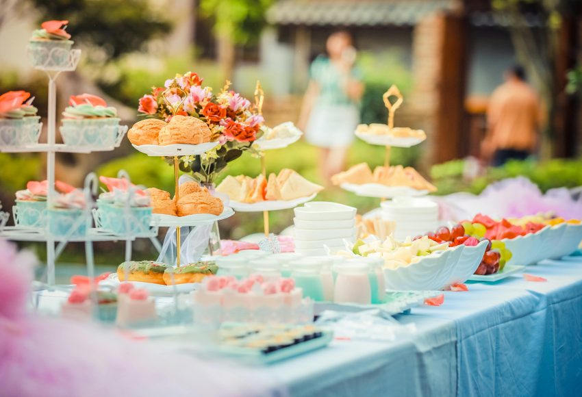 A vibrant outdoor buffet table showcasing an array of colorful pastries and fruits, perfect for parties.